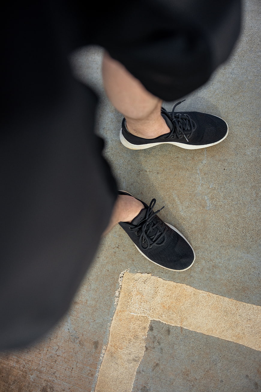 High angle view of black sneakers on concrete pavement