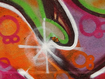 Painted Lady Butterfly Resting on Colorful Graffiti Wall