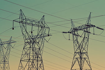Silhouette of electricity pylons against gradient sky
