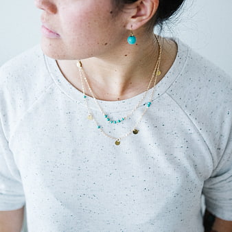 Woman Wearing Layered Gold and Turquoise Jewelry