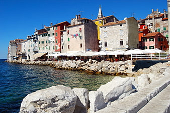 Colorful coastal town buildings along rocky seaside promenade