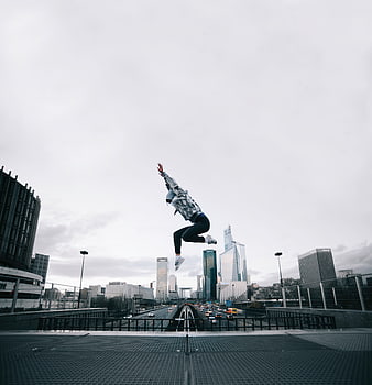 Woman jumping high in urban cityscape with skyscrapers
