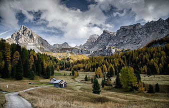 Autumn Landscape in the Dolomites with Wooden Cabins and Golden Forest