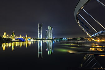 Modern City Skyline at Night with Water Reflections