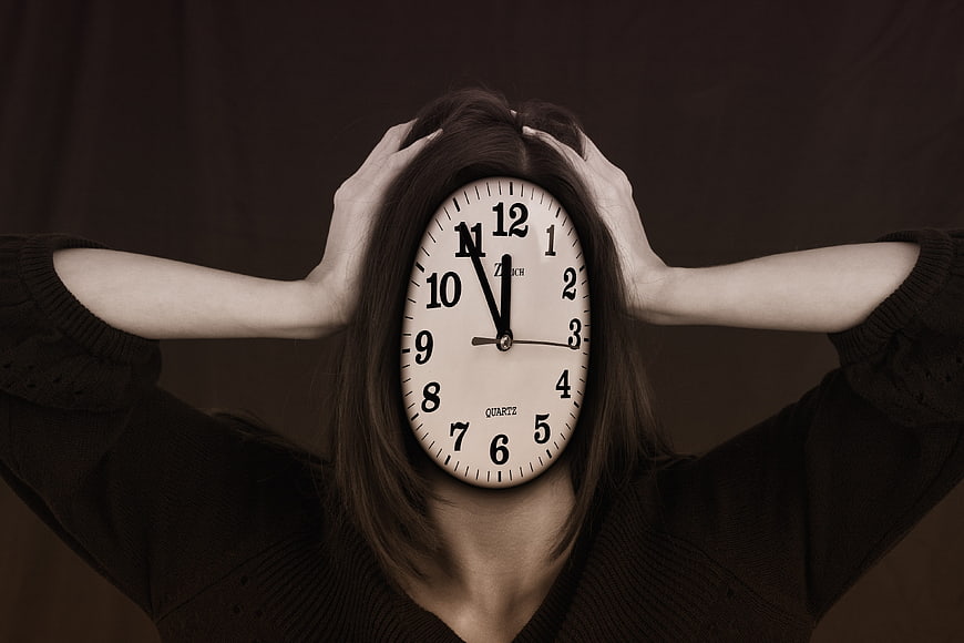Woman with clock face holding head in stress