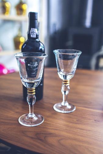 Two empty wine glasses and bottle on wooden table