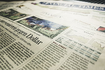 Financial newspaper with stock market charts and dollar bill