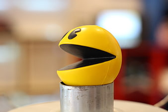 Yellow Pac-Man Figure On Metal Stand With Blurred Background