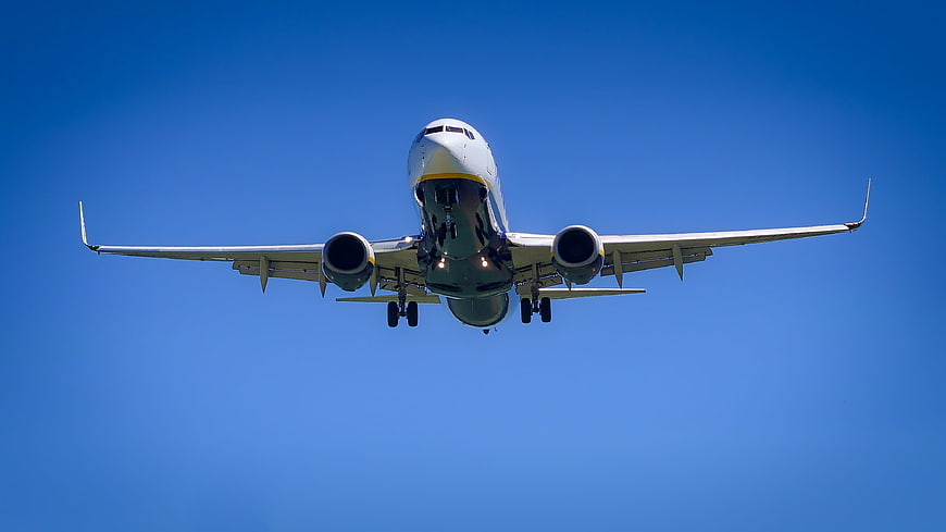 Commercial Airplane Landing Against Blue Sky