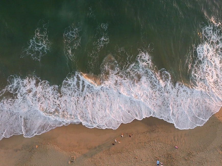 Aerial View of Ocean Waves Crashing on Sandy Beach