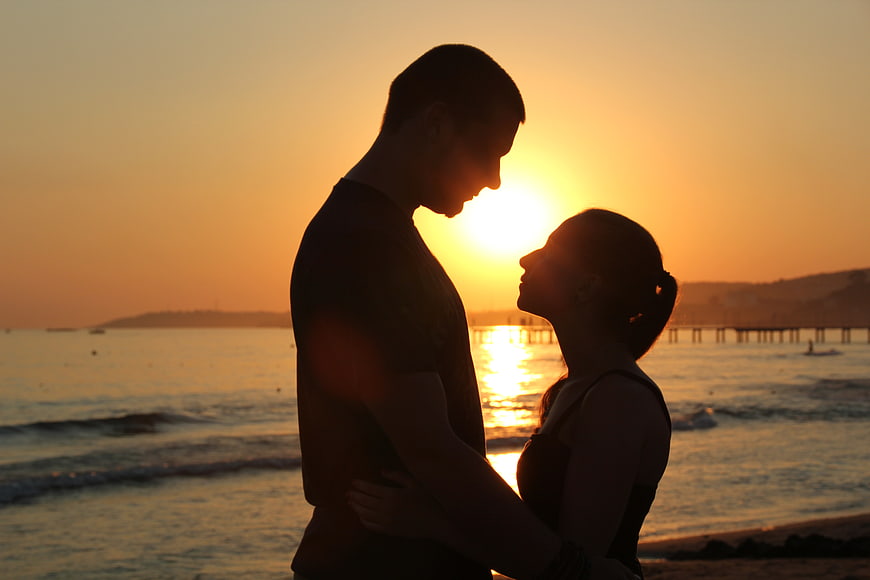 Silhouette of a romantic couple embracing at sunset on the beach