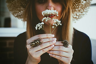 Woman with Straw Hat Holding White Flowers and Beetle Ring