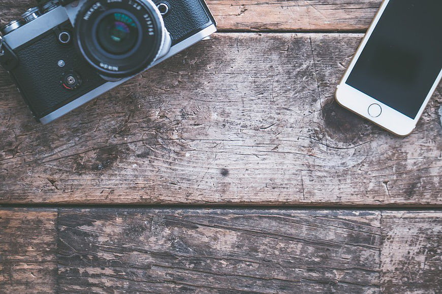 Vintage Camera and Smartphone on Rustic Wooden Table