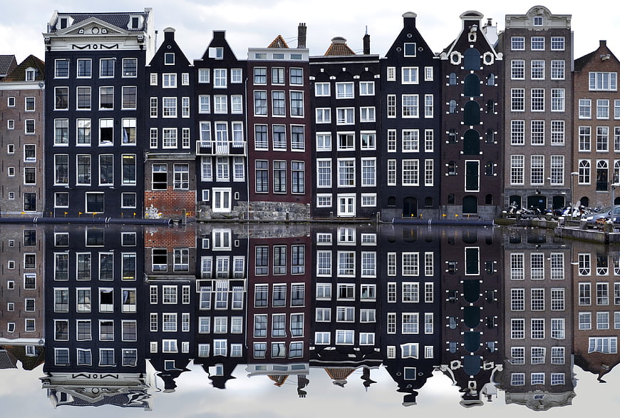 Reflections of historic canal houses in Amsterdam, Netherlands