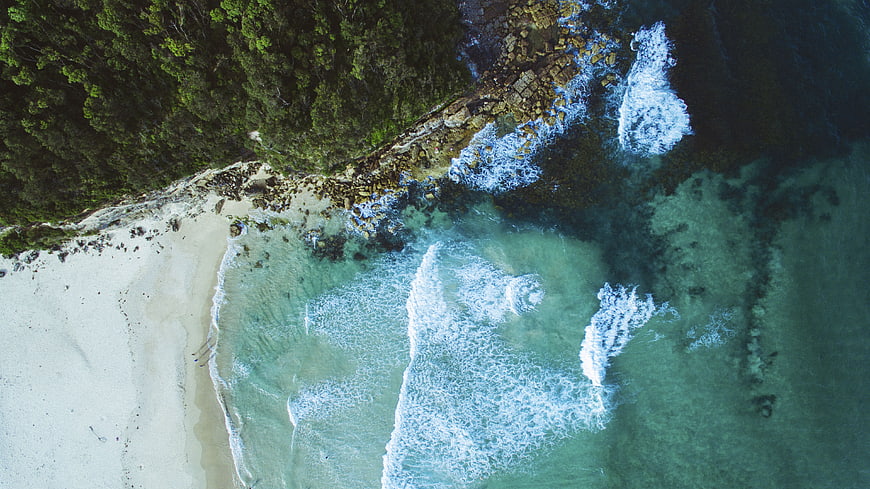 Aerial View of Turquoise Ocean Waves Crashing on Sandy Beach