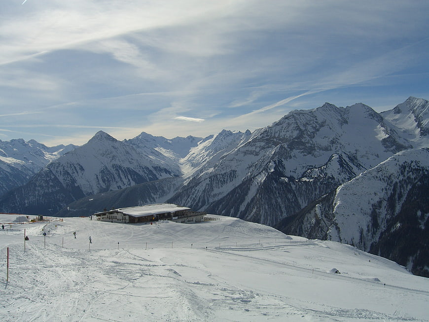 Snowy mountain landscape with ski resort and blue sky