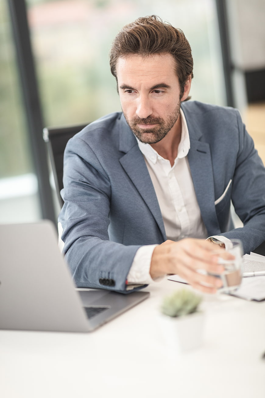 Professional businessman working at office desk with laptop