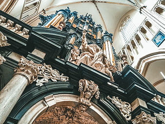 Baroque church interior with pipe organ and religious sculpture