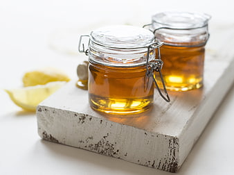 Jars of Honey on Wooden Board with Lemon Slices