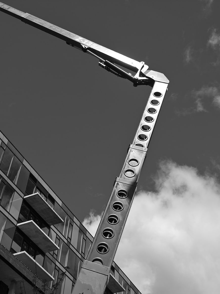 Black and white construction crane arm against sky