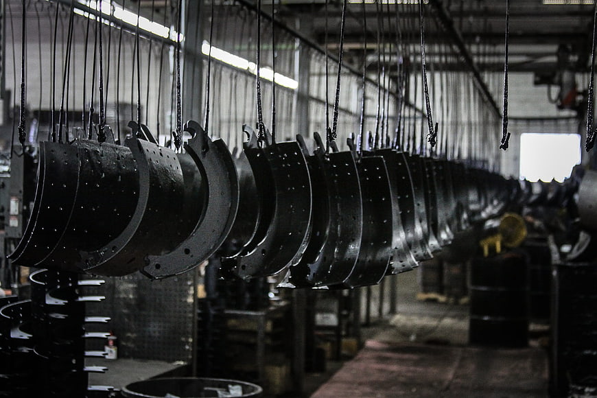 Industrial brake drums hanging in manufacturing factory