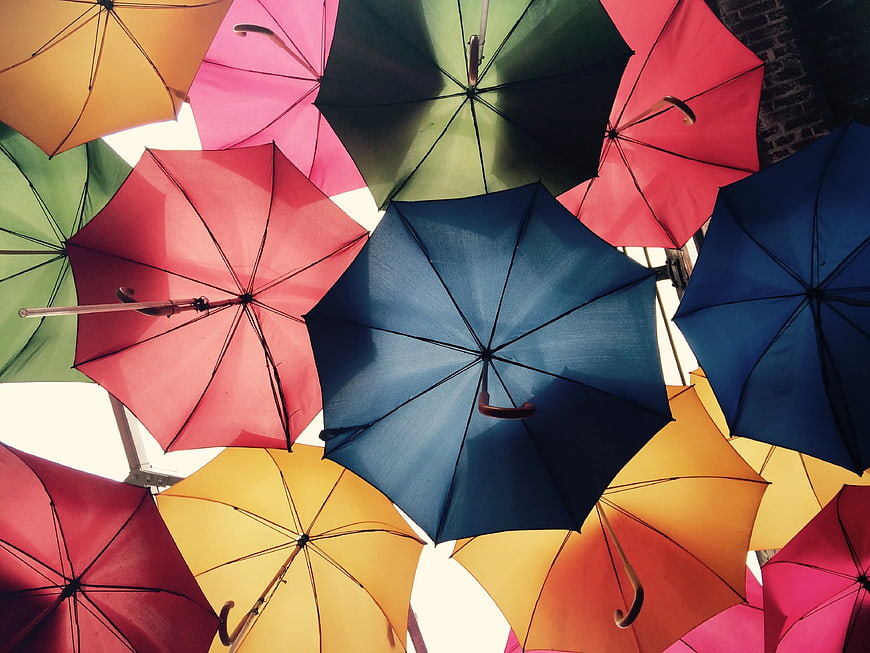 Colorful umbrellas hanging overhead in a vibrant street art installation