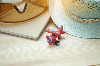 Summer travel accessories with toy airplane on wooden table