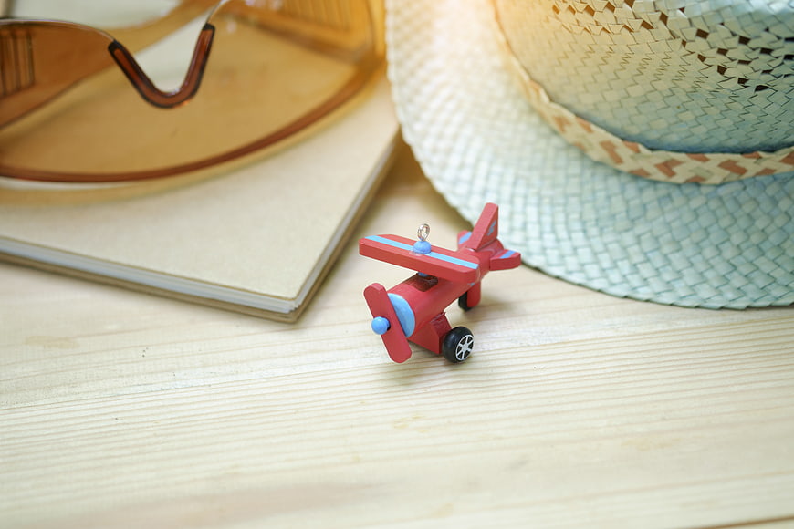 Summer travel accessories with toy airplane on wooden table