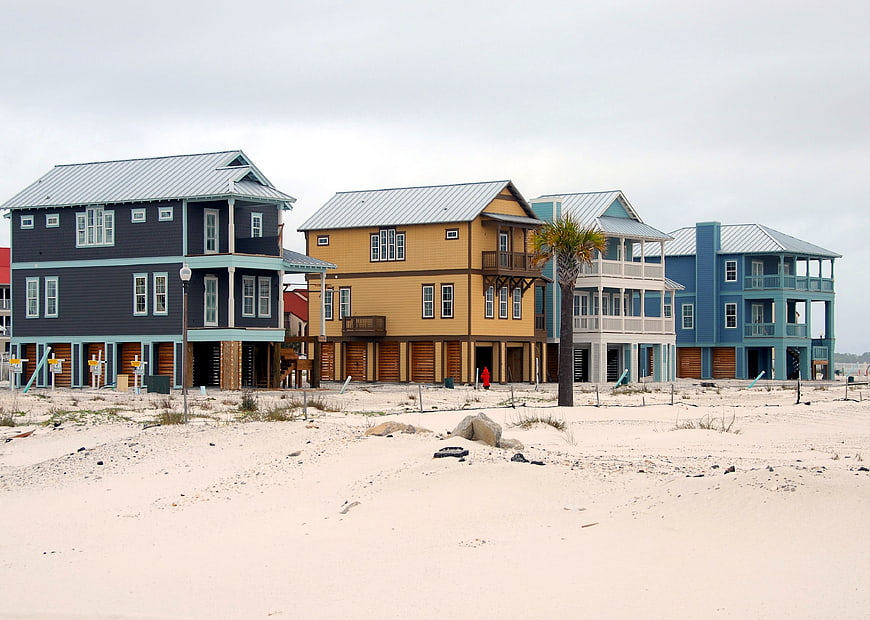 Row of colorful beach houses under construction on sandy shore