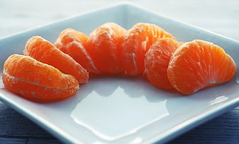 Peeled mandarin orange segments on a white square plate