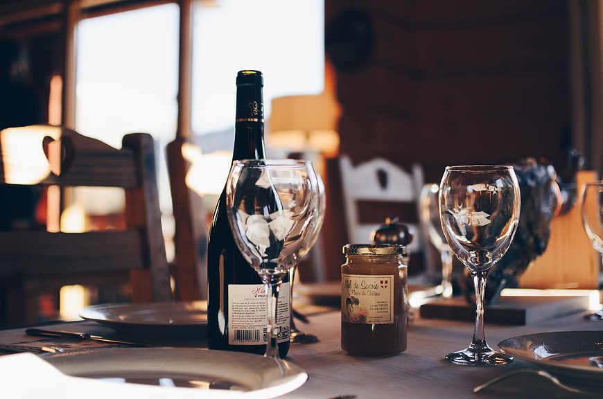 Rustic dining table setting with wine bottle and glasses