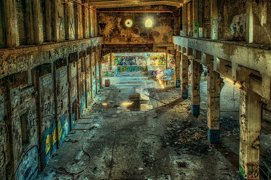 Abandoned industrial factory interior with graffiti and decay