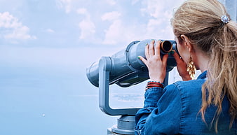 Woman Looking Through Coin-Operated Binoculars at Ocean View