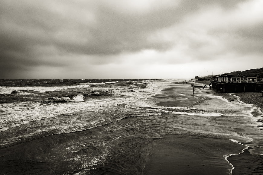 Dramatic Black and White Stormy Beach with Pier