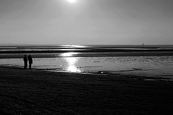 Silhouetted Couple Walking on Beach at Low Tide