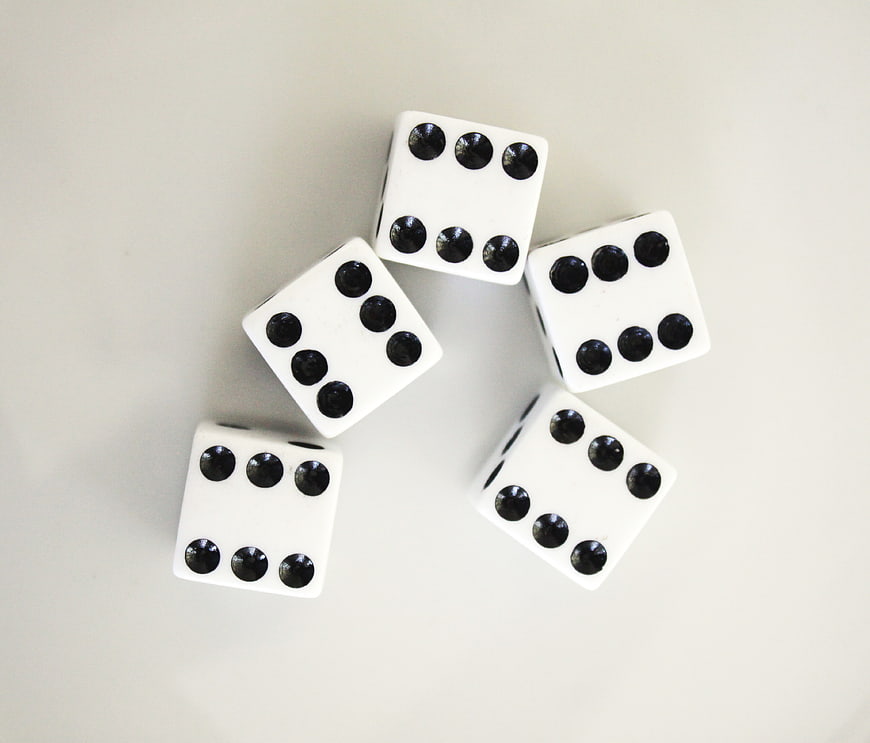Five white dice showing sixes on a white background