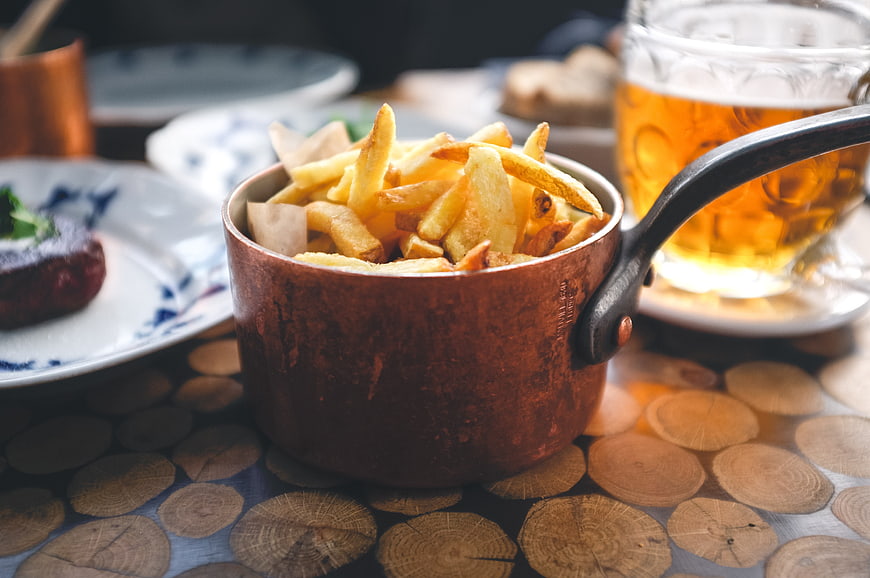 Copper pot of french fries with beer and steak