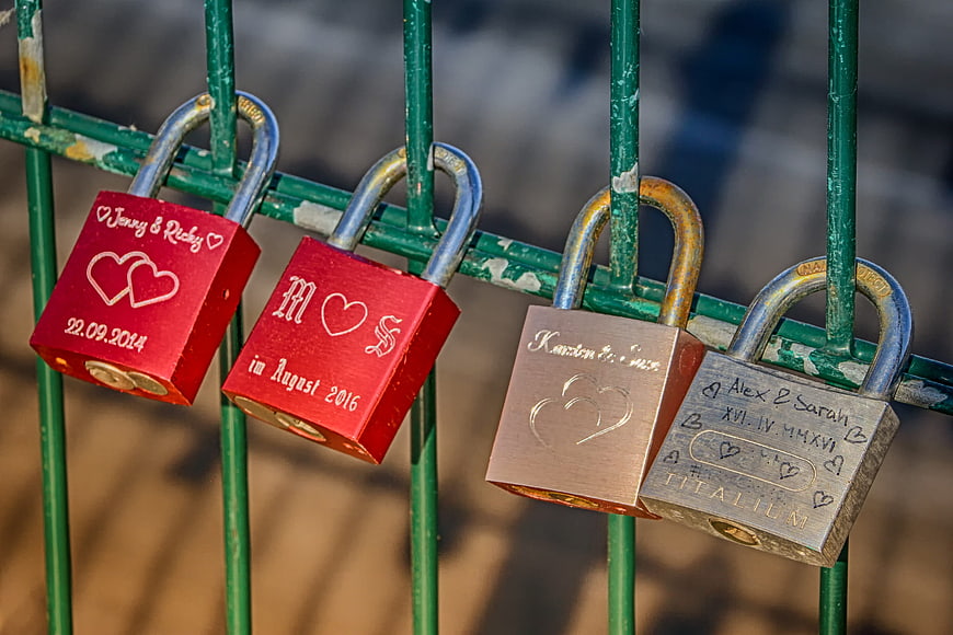 Engraved Love Locks on Green Metal Fence