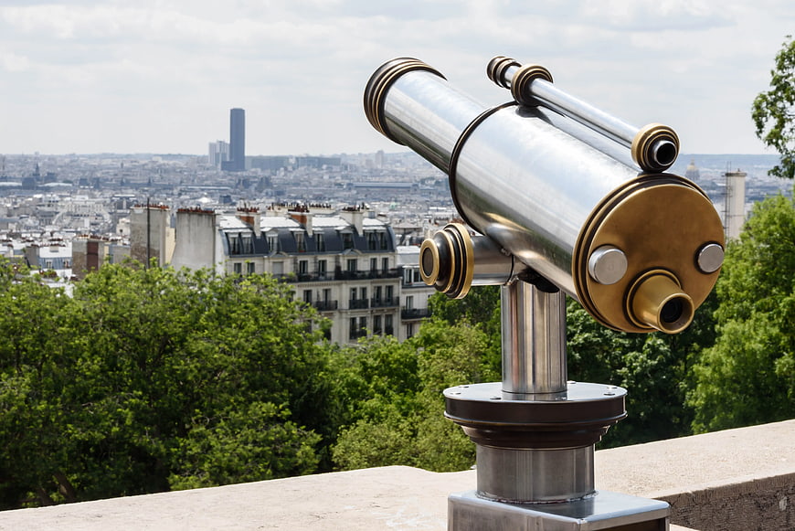 Telescope overlooking Paris cityscape with Montparnasse Tower