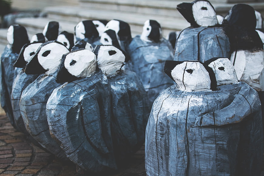 Hand-carved wooden penguin sculptures in a group
