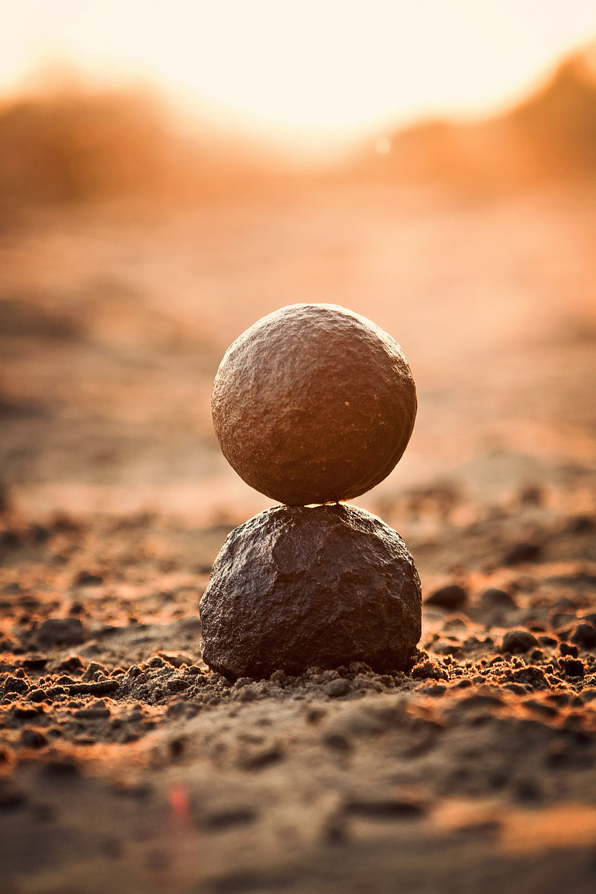 Balanced stones on desert ground at sunset