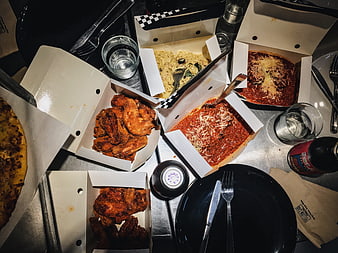 Overhead view of assorted Italian takeout food on metal table