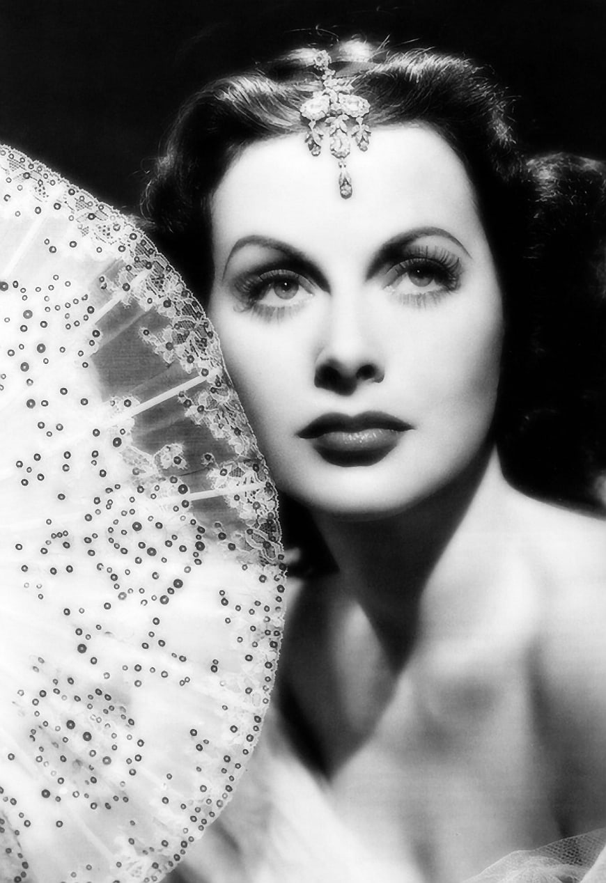 Vintage black and white portrait of glamorous woman with fan
