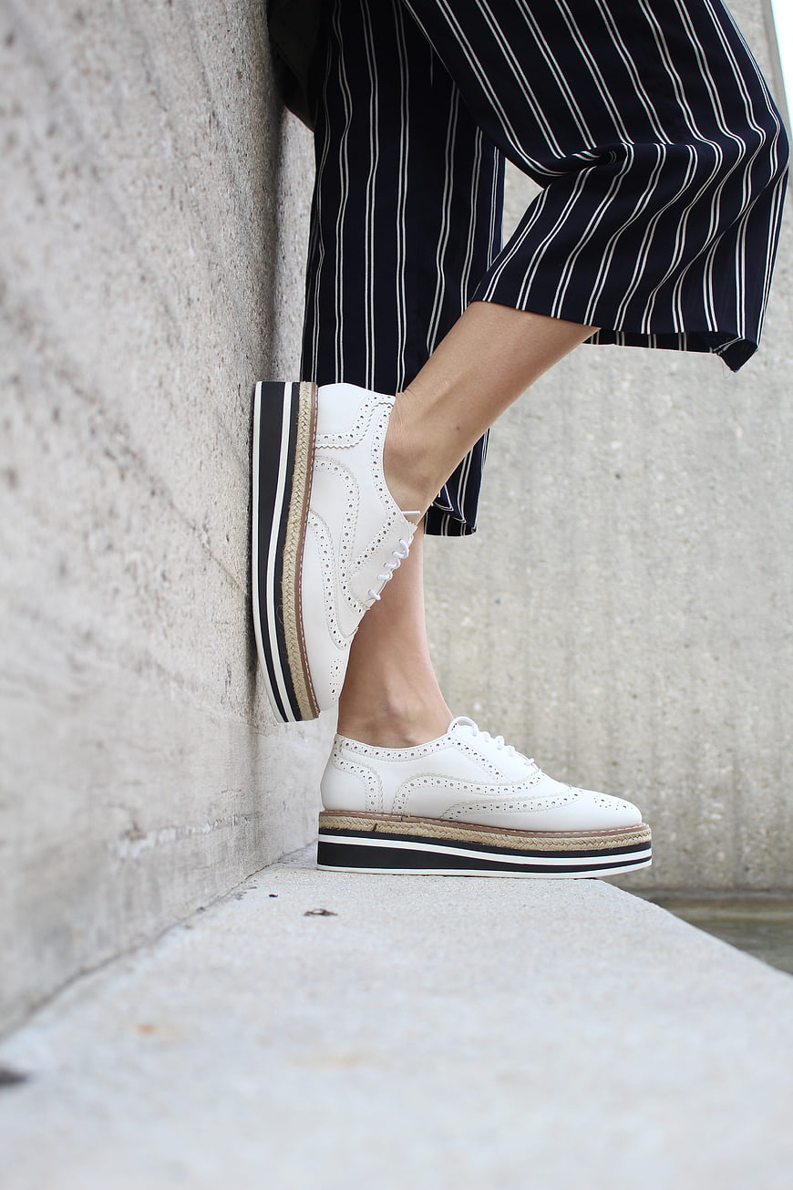White Platform Brogue Sneakers With Striped Trousers