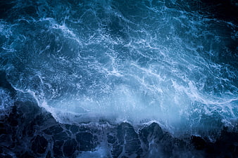 Aerial View of Crashing Blue Ocean Waves and Sea Foam