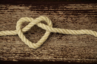 Rope Heart Knot on Weathered Wooden Background