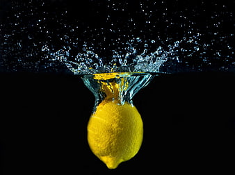 Fresh Lemon Splashing into Water on Black Background