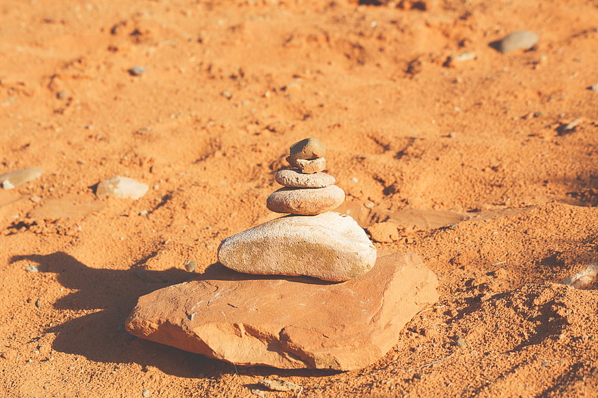 Stacked stones on red sand in desert landscape