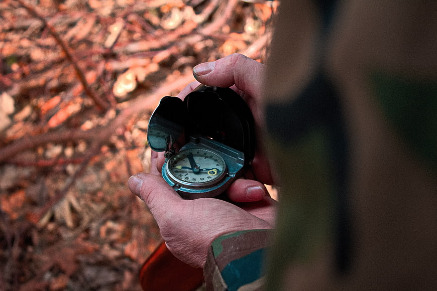 Hand Holding Vintage Compass In Autumn Forest