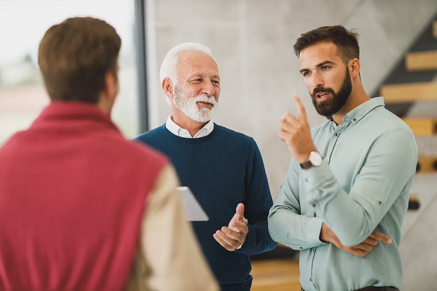 Senior and young men discussing business strategy in office